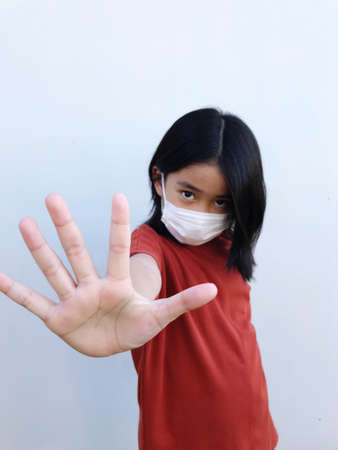 6 year old girl wearing a white mask, protects against coronavirus or COVID-19の写真素材