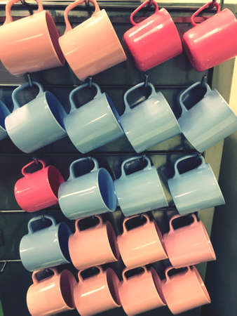 Plastic cups of various colors are hung next to the water dispenser.の写真素材