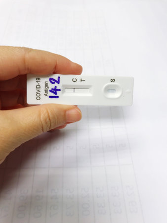 hand holding ATK or antigen test kit with negative results, meaning no coronavirus has been...