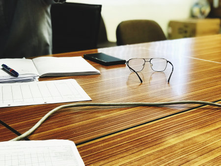 Pictures of glasses and various notebooks on the conference room table
