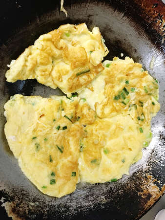 The scallion omelet being fried in a pan is very appetizing, causing a feeling of hunger.の写真素材