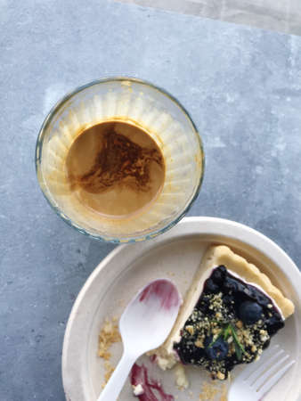 Appetizing blueberry pie on a paper plate, served with delicious dirty coffee.