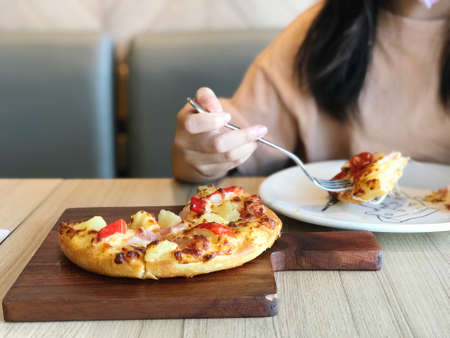 Image of consumer eating pizza in a shop, pizza time to happy mealの写真素材