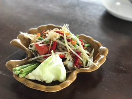 top view of Somtum papaya Salad with fresh crab is famous spicy salad Thai food, food travel and...