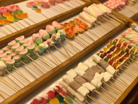 Colorful candies on sticks in a row at a market stallの写真素材