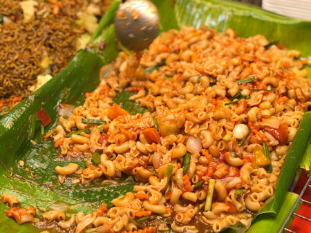 Fried macaroni with vegetables and chili sauce on banana leafの写真素材
