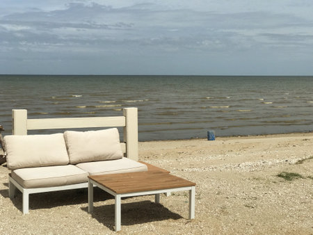 Beach chair and table on the beach with sea and sky backgroundの写真素材