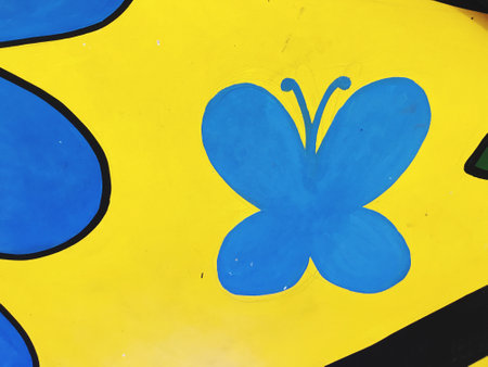 butterfly painted on a yellow wall, closeup of photoの写真素材