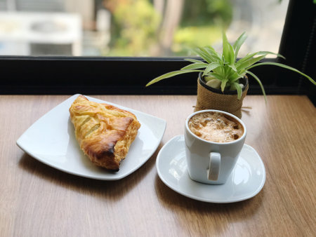 Coffee and croissant on the table in coffee shopの写真素材
