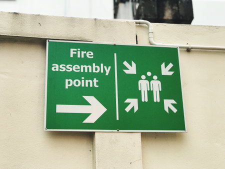 Emergency exit sign on the wall of a building. Keep your distance.の写真素材