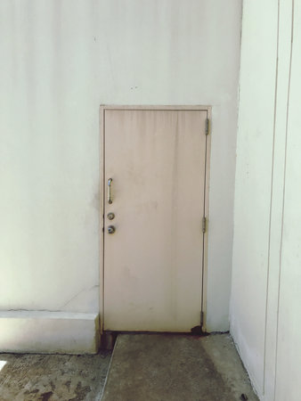 Old steel door in the white wall, vintage tone, stock photoの写真素材
