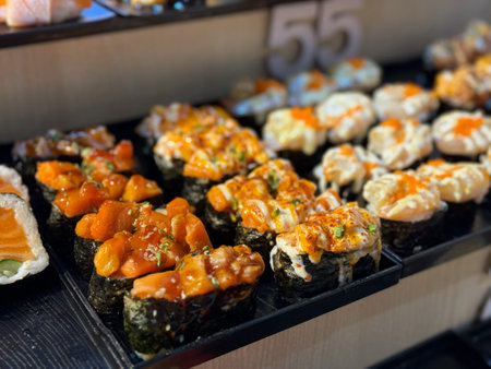 Sushi rolls with salmon and eel on display at a Japanese restaurantの写真素材