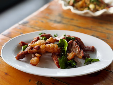 Thai style stir fried pork with basil and garlic on white plateの写真素材
