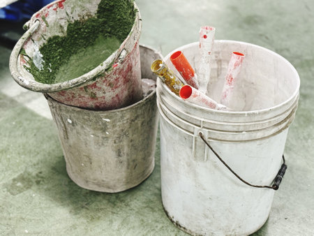 Paint bucket and paintbrush on cement floor, vintage color toneの写真素材