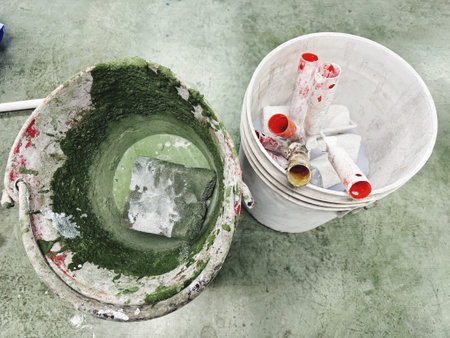 Paint bucket and paint roller on cement floor, closeup of photoの写真素材