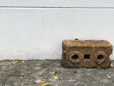 Old brick on the cement floor and white wall background, Thailand.の写真素材