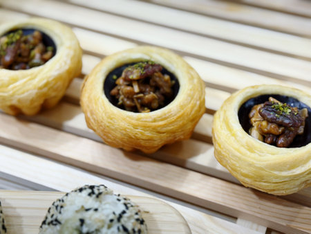 Tasty sweet buns with nuts and raisins on wooden tableの写真素材