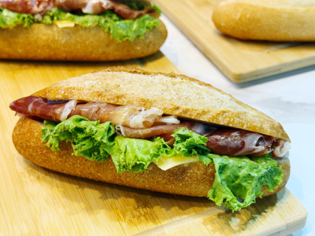 sandwich with bacon and lettuce on a wooden board, close-upの写真素材