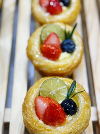Tartlets with berries and lime on a wooden stand. Selective focus.