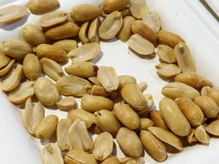 Peanuts in a white plate on a white background, close-up