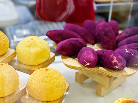 Sweet potatoes on display in a market stall, closeup of photoの写真素材