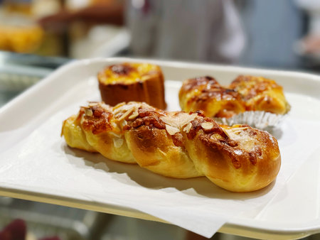 Close up of buns with almonds on a plate in a bakeryの写真素材