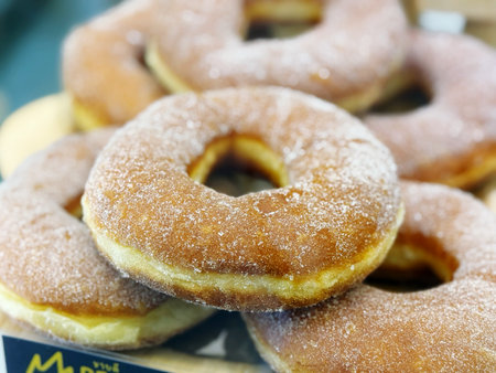 Donuts with sugar on display in a bakery shop, closeupの写真素材
