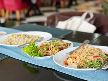 Thai spicy papaya salad with shrimp on white plate on tableの写真素材