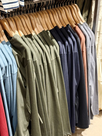 Colorful shirts on hangers in a clothing store, close up