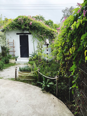 Old house in the garden with flowers and plants. Vintage style.