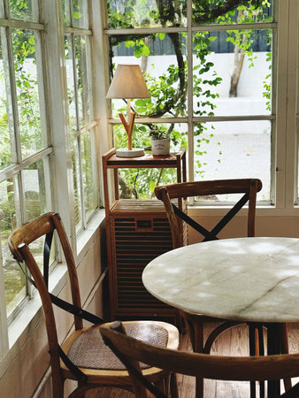 Wooden table and chairs in a cozy room with a large window