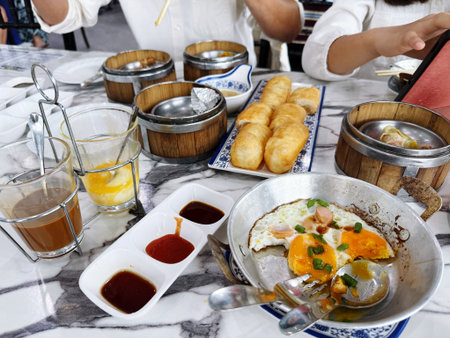 breakfast in a restaurant with fried egg, fried pork and breadの写真素材