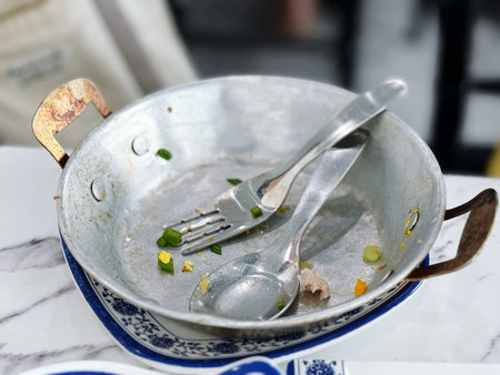 Stainless steel pan with cutlery on a marble tableの写真素材