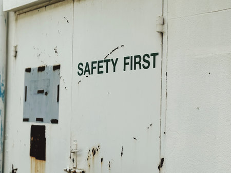 Safety first sign on the white wall of an old factory building.の写真素材