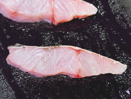 Slices of fresh fish on frying pan. Toned.の写真素材