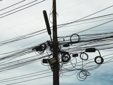 Electricity post with many electrical wires and cables on the sky background.の写真素材