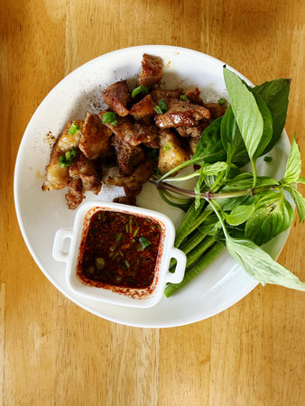 Thai style fried pork with chili sauce on wooden table, Thai foodの写真素材
