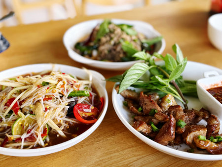 Spicy papaya salad with pork on wooden table, Thai foodの写真素材