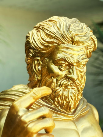 Golden statue of a man with a beard and mustache, closeup of photo