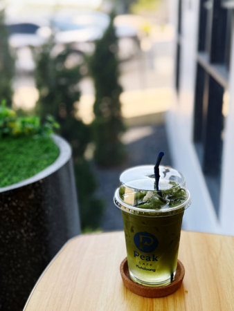Iced matcha green tea on wooden table in coffee shop.