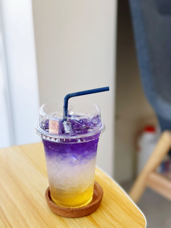 ice tea in plastic cup with straw on wood table in coffee shopの写真素材