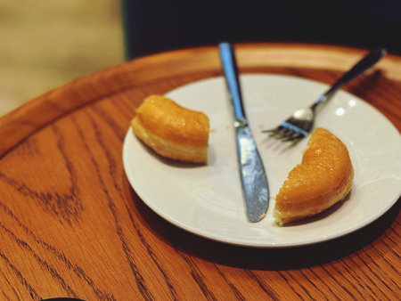 Doughnuts on white plate with fork and knife in coffee shop
