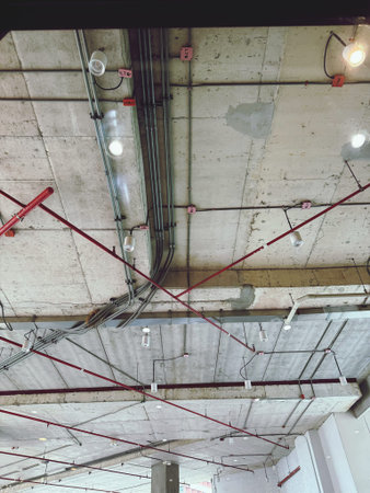 Interior of a building under construction with scaffolding and ceiling lights