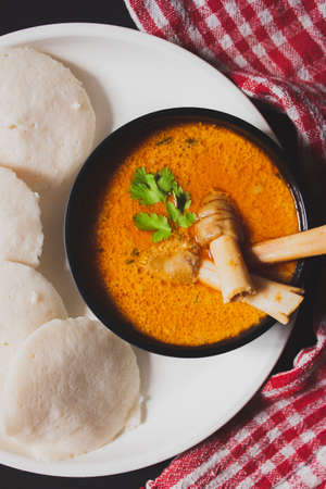 Closeup view of Idly with Indian style spicy Mutton or Lamb curry with kitchen napkin
