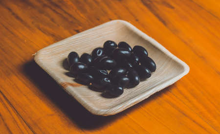 Black apple on a Betel palm leaf plateのeditorial素材