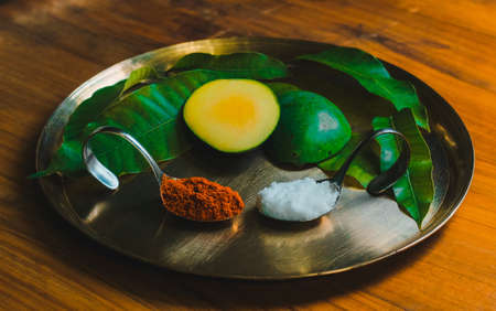 Mango powder in spoon and fresh mango fruit on wooden table.の写真素材