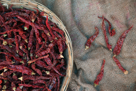 Pile of dried red chili peppers background, top view.の写真素材