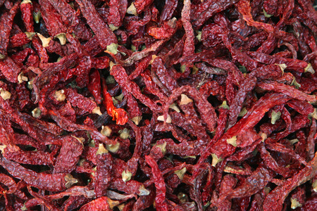 Pile of dried red chili peppers background, top view.の写真素材
