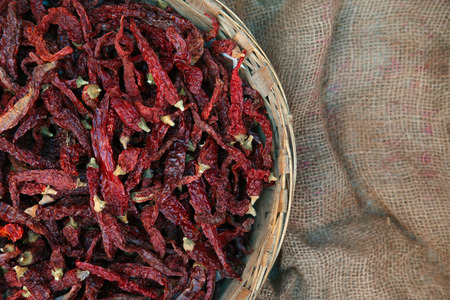 Pile of dried red chili peppers background, top view.の写真素材