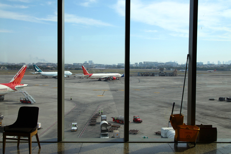 Mumbai,India - February 11, 2018: Mumbai Airport overview showing airplanes parked and the runway. Also see the air traffic control towers.のeditorial素材